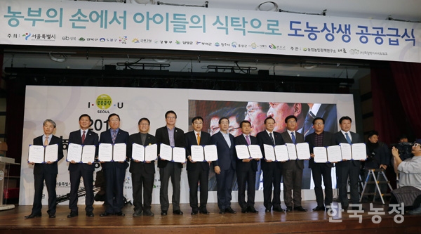 지난 4~5일 서울여성플라자에서 열린 ‘도농상생 이구동감 소통마당’에서 1대1 공급협약을 맺은 서울시 자치구 및 지자체장들이 단상에서 협약서를 들어 보이고 있다. 한승호 기자