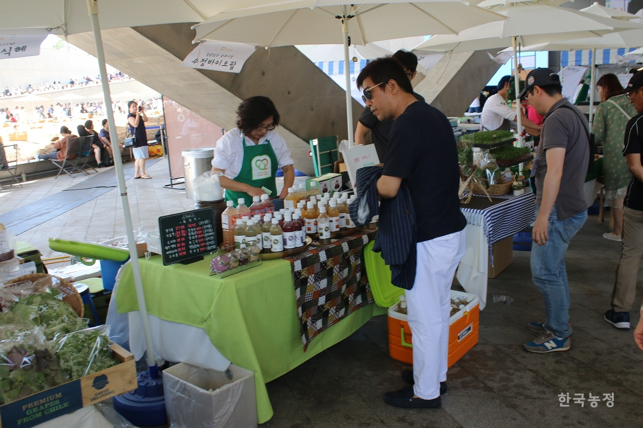 2일 서울 동대문디자인플라자에서 열린 유기데이 행사를 관람 중인 시민이 유기농 주스 판매 부스 앞에서 물품을 구경 중이다.