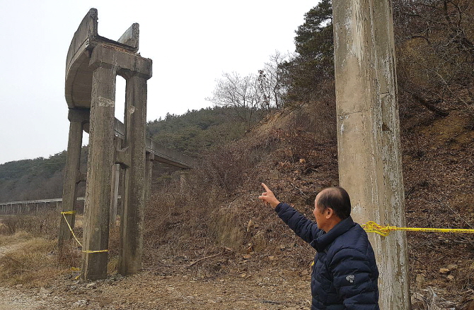 낡은 고대선 수로교가 떨어져 나간 부분을 피해농민인 장재룡씨가 가리키고 있다.