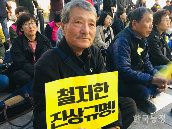 세월호충북대책위가 개최한 추모문화제에 참가한 농민이 ‘철저한 진상규명’이라는 피켓을 들고 있다.