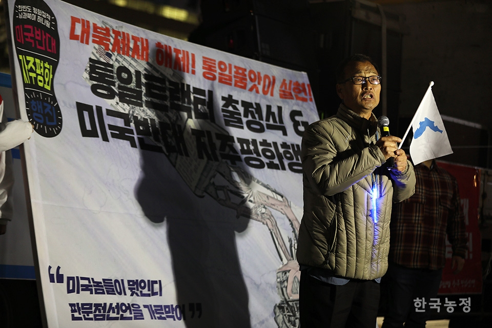 지난 26일 서울 광화문 세종문화회관 앞에서 열린 통일트랙터 출정식에 참가한 광주전남 농민들이 지역에서 가져온 트랙터에 현수막을 게시하고 있다. 한승호 기자