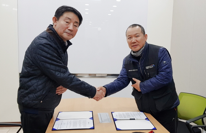 강남경 농협물류 대표이사(왼쪽)와 박노식 공공운수노조 화물연대본부 농협물류안성분회장이 지난달 26일 합의서에 서명 후 악수를 나누고 있다.