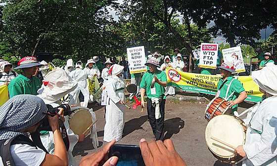 흰 상복을 입은 한국 농민투쟁단이 풍물을 치며 WTO 반대를 외치고 있다.