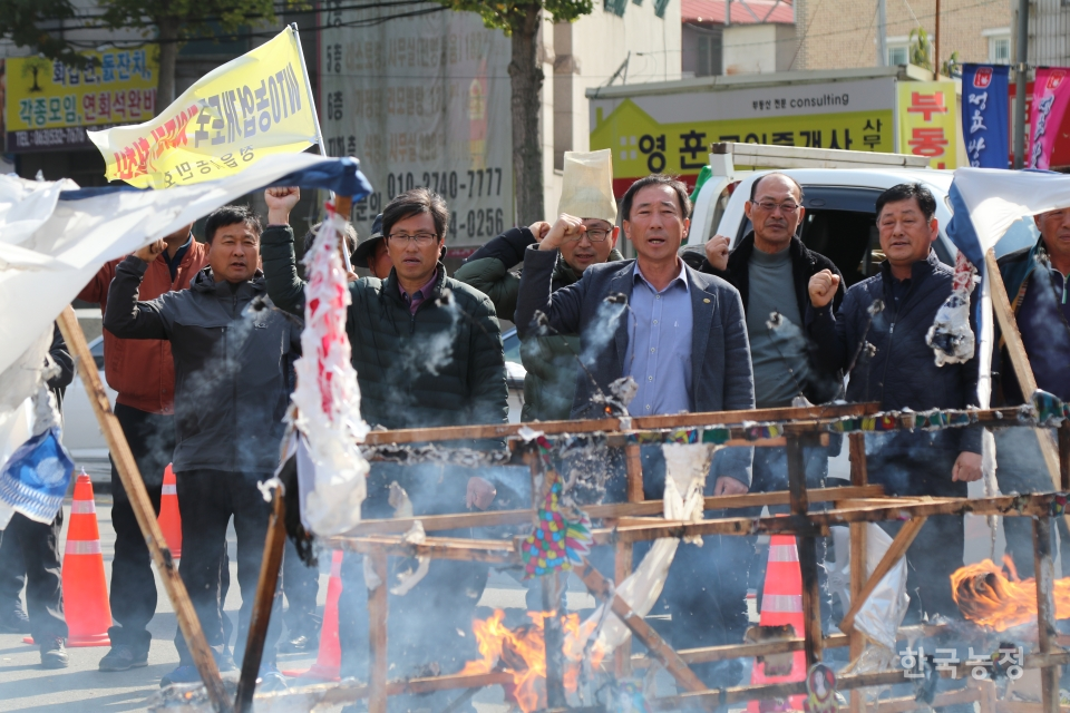 지난 11일 ‘농업인의날’에 전북 정읍시청 앞에서 근조상여가 불타는 가운데 전북 농민들이 농민가를 부르고 있다.
