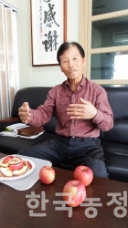 김동진 한국유기농사과연구회 대표가 유기농으로 재배한 사과를 보여주며 유기과수농업의 특성을 설명하고 있다.