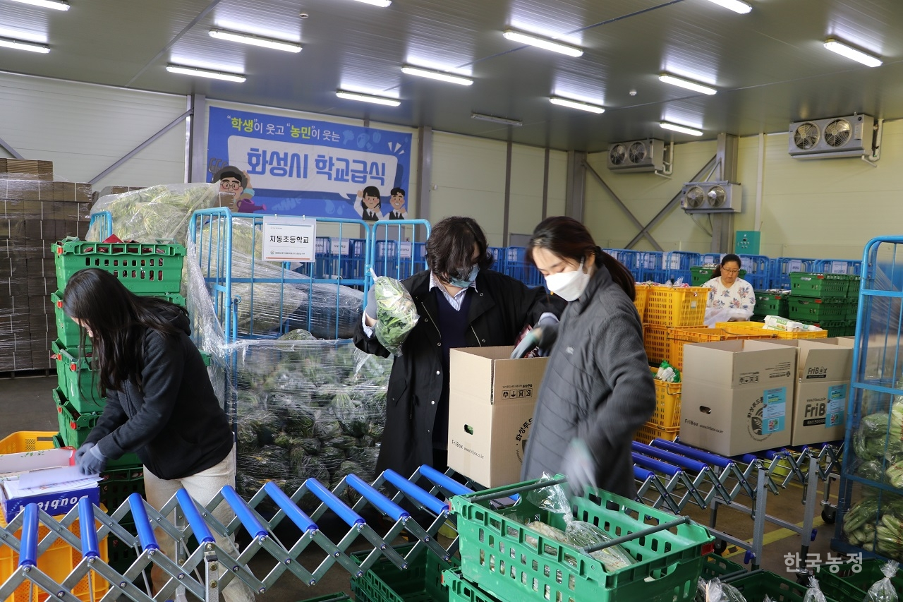 지난달 29일 경기도 화성시의 화성푸드통합지원센터에서 직원들이 관내 농가로부터 100% 전량수매한 친환경농산물을 꾸러미로 포장하고 있다.