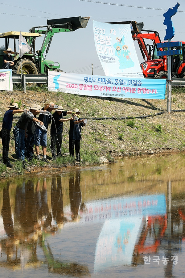 농민들이 전국 팔도에서 가져온 물을 논에 붓는 상징의식을 펼치고 있다.