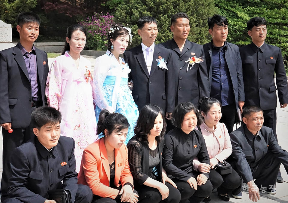 결혼식장 가기에 앞서 신랑 신부가 친구들과 함께 야외촬영을 마치고 모여서 기념사진을 찍고 있다. 2019년 5월 개성 고려태조 왕건릉.