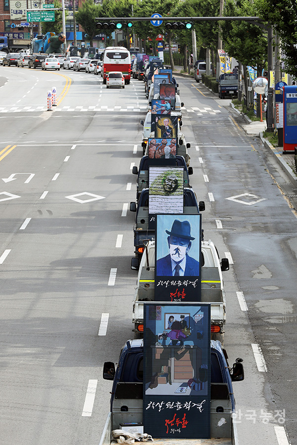 전두환 풍자그림을 실은 518대의 트럭이 망월동 묘역에서 5.18민주광장으로 행진하고 있다.