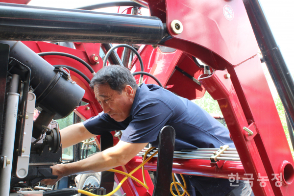 지난 7일 박흥식 전국농민회총연맹 의장이 배터리가 방전된 트랙터를 정비하고 있다.