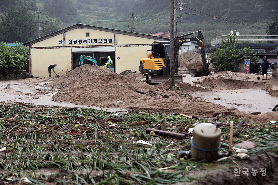 산으실마을 주민들이 빗물에 휩쓸려 내려온 토사를 중장비를 이용해 치우고 있다.