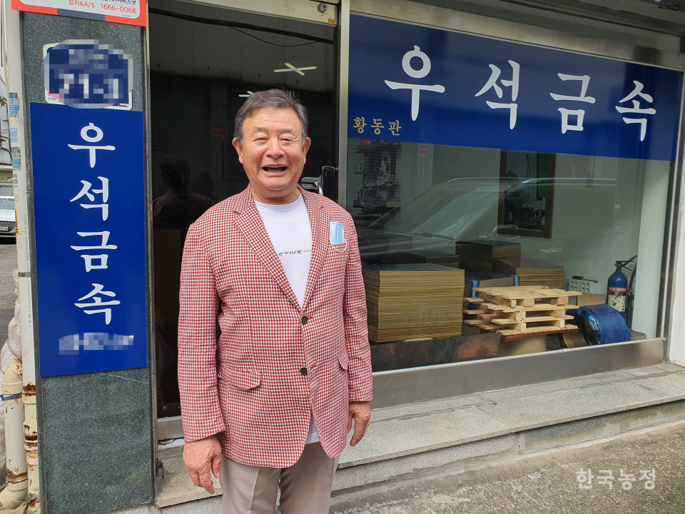 우종석 어르신이 서울 용두동에 있는 자신의 사무실 앞에서 환하게 웃고 있다.