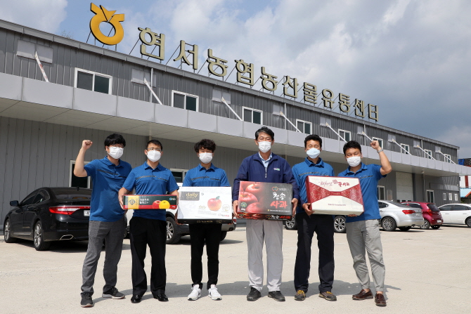 지난 8일 김해환 현서농협 조합장(오른쪽 세 번째)과 직원들이 농산물유통센터(APC) 앞에서 올해 출하된 부사와 황금사과 등의 상품을 들고 파이팅을 외치고 있다.