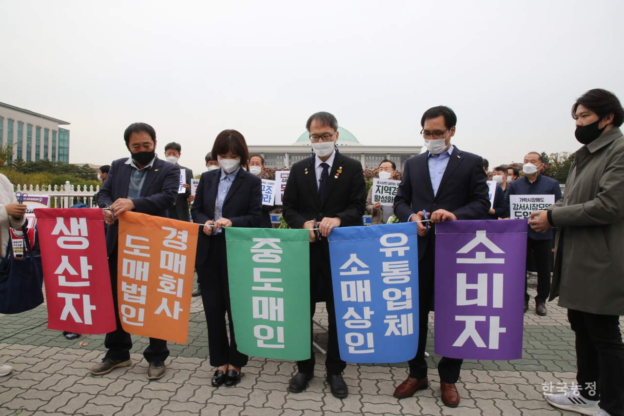 기자회견을 마친 뒤 박주민 의원과 각 단체장들이 현행 유통단계를 가위로 잘라내는, 유통개혁 상징의식을 하고 있다.