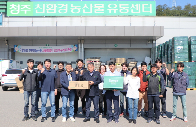 오창농협 청주친환경농산물유통센터에서 김영우 조합장(왼쪽 일곱 번째)과 직원들이 지역 생산 친환경농산물을 들고 파이팅을 외치고 있다.