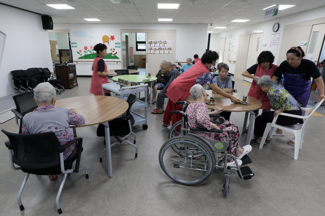 충남 아산의 인주농협요양원에서 요양보호사들이 간식을 나눠주며 환자들을 보살피고 있다. 한승호 기자
