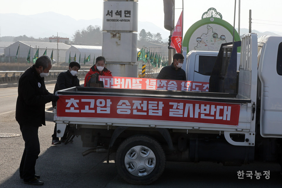 행진을 시작하기 전, 주민들이 대책위에서 나눠준 현수막을 트럭 적재함에 매달고 있다.