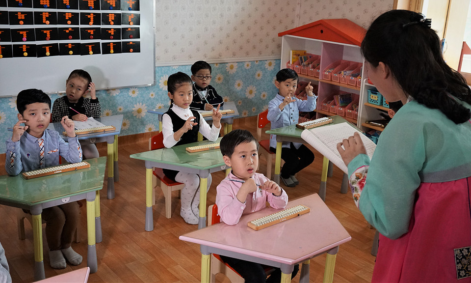 창광유치원 아이들이 주산 선생님의 설명을 들으며 손을 쓰는 계산법을 익히고 있다.