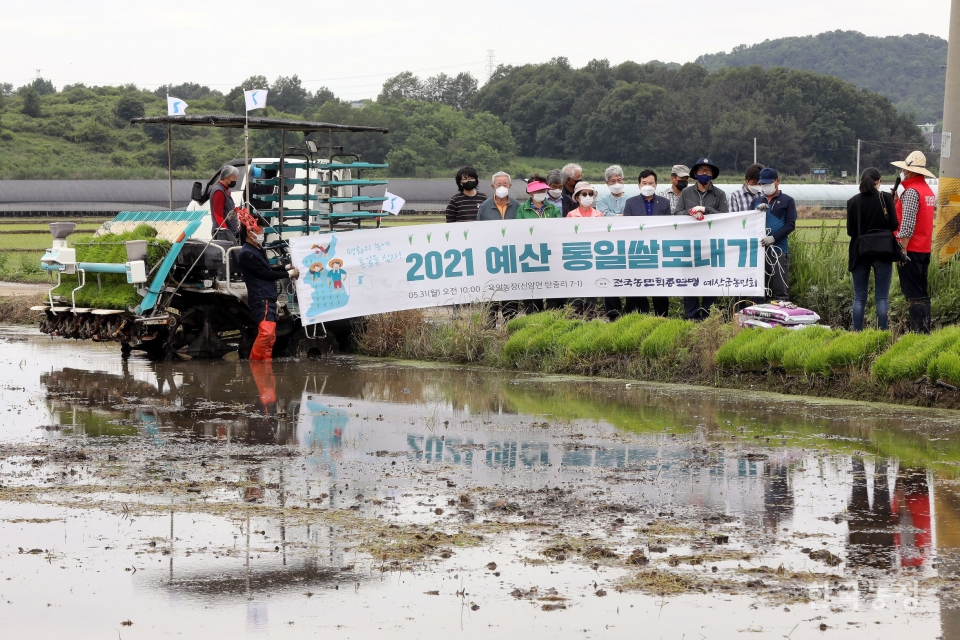 지난달 31일 예산군농민회 통일쌀모내기 행사가 열린 가운데 농민들이 통일쌀 경작지 앞에서 모내기를 알리는 행사를 갖고 있습니다. 한승호 기자<br>