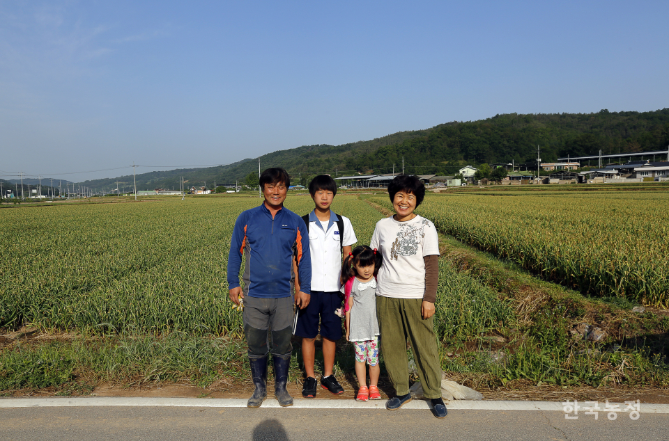 지난 2014년 한국농정신문의 1면을 장식했던 김상권, 황정미씨 가족의 모습. 당시 중학생이었던 둘째 아들이 제대하는 올해도 부부는 같은 마늘논에서 농사를 놓지 않고 이어갑니다.