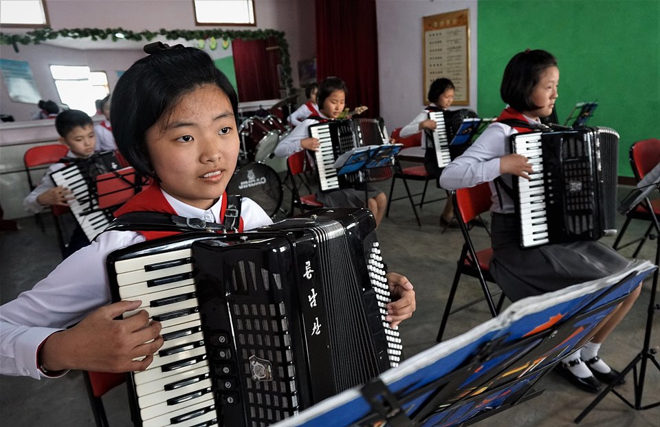선교초급중학교 음악실에서 남녀 학생들이 소조활동(방과후 과외활동)으로 손풍금을 배우고 있다.