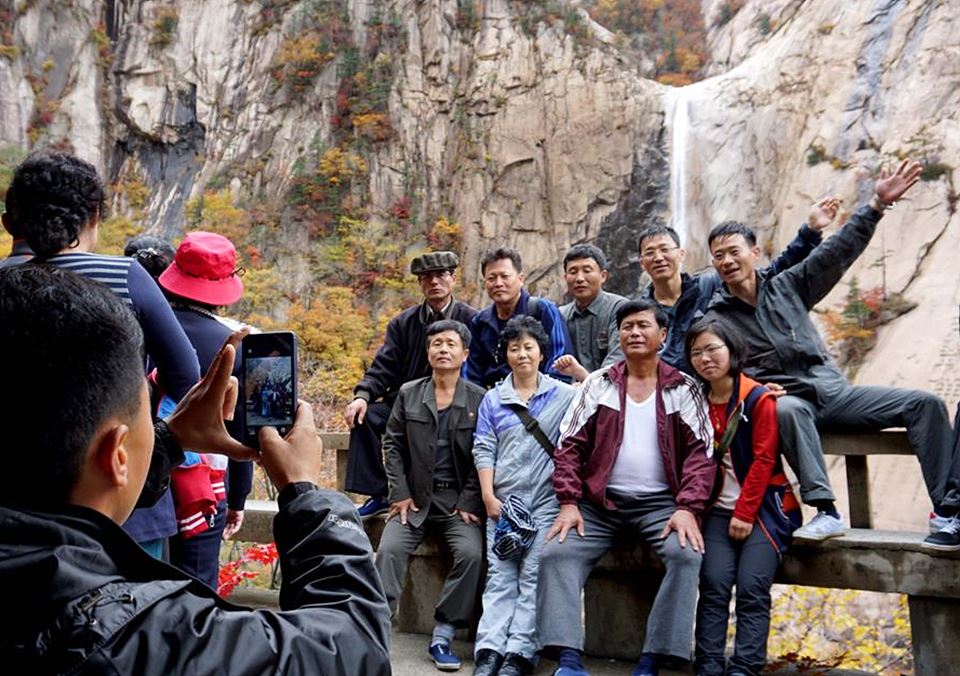 금강산 관광을 온 북녘 주민들이 구룡폭포를 배경으로 단체사진을 찍고 있다.