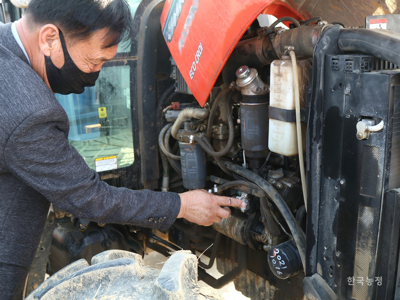 지난 1일 전라남도 강진군에서 농민 A씨가 고장난 트랙터의 엔진 부분을 가리키고 있다.