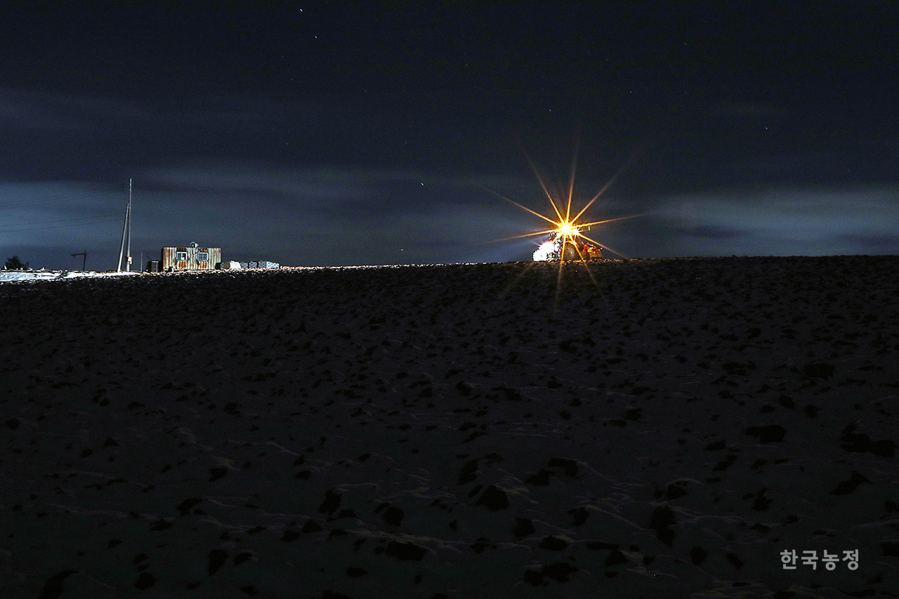 새해를 닷새 앞둔 지난해 12월 27일, 어둠이 짙게 깔린 비탈진 눈밭 위로 트랙터 한 대가 서서히 이동한다. 갈아엎어 울퉁불퉁한 밭을 넘어 집으로 돌아가는 길, 짙은 어둠을 뚫고 퍼지는 불빛이 주위를 환히 밝힌다. 탄소중립 시대, 농업은 탄소를 절감하고 기후위기를 막는 산업으로 우리나라의 희망이 될 터, 새해는 농업·농촌·농민의 가치를 드높이는 한 해가 되길 염원한다. 한승호 기자