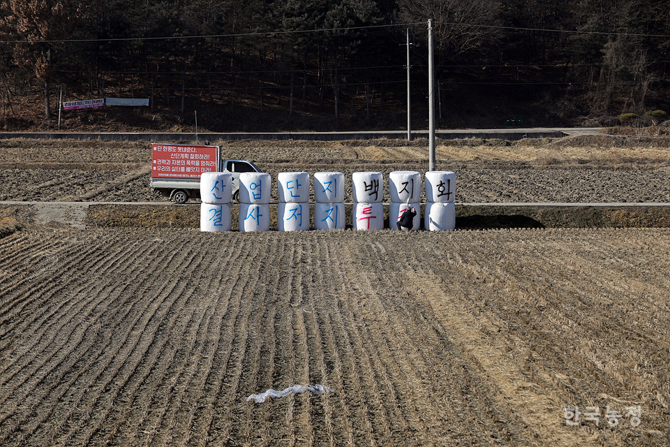김기형 반대대책위원장이 진천 사당마을 앞 들녘에 놓인 ‘공룡알’에 ‘산업단지백지화 결사저지투쟁’이라고 적고 있다.