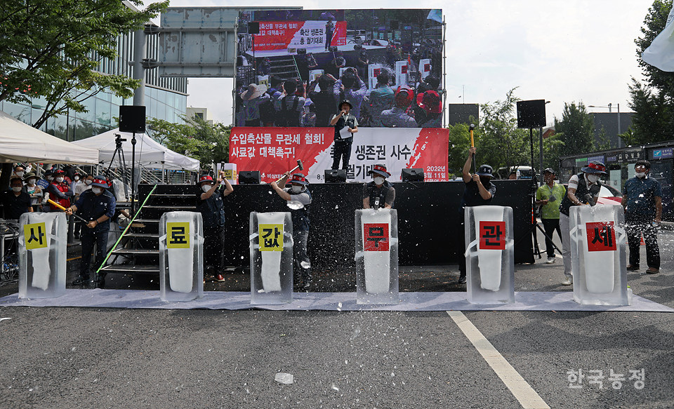 총궐기대회에 참석한 축산단체 대표들이 ‘사료값 무관세’가 적힌 얼음을 깨는 상징의식을 펼치고 있다. 한승호 기자