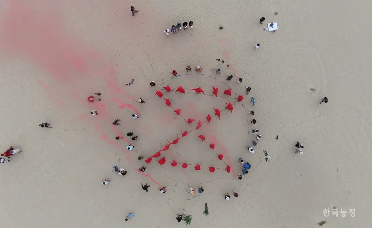 지난 15일 강원도 강릉시 옥계해변에서 열린 퍼머컬처네트워크 출범식 중 참가자들이 ‘기후위기로부터의 지구 구조’를 위해 신호를 보내고 있다. 퍼머컬처네트워크 제공