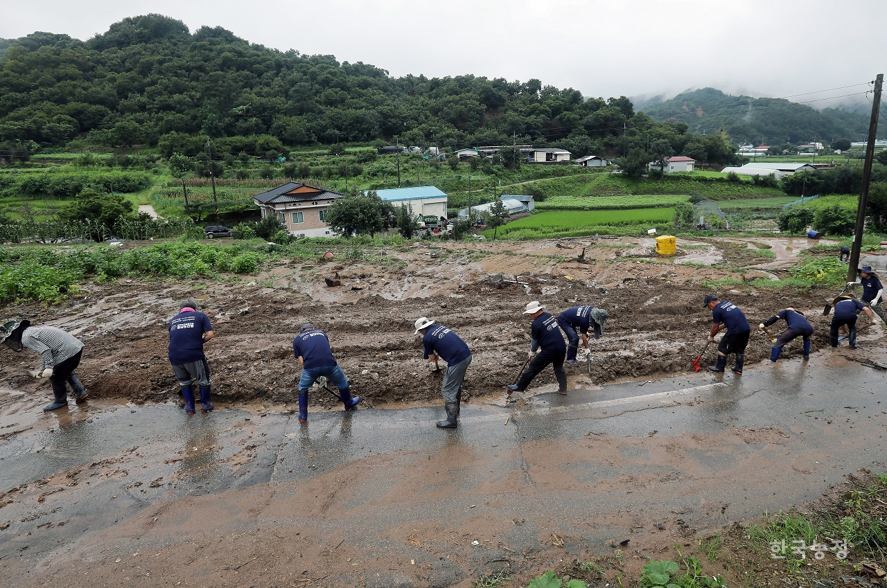 적지 않은 비가 오락가락했던 지난 23일 충남 부여군 은산면 장벌리에서 전농 충남도연맹 소속 농민들이 14일 시간당 100mm가 넘는 폭우로 수해를 입은 마을을 찾아 토사를 치우는 등 수해복구 작업을 하고 있다. 한승호 기자