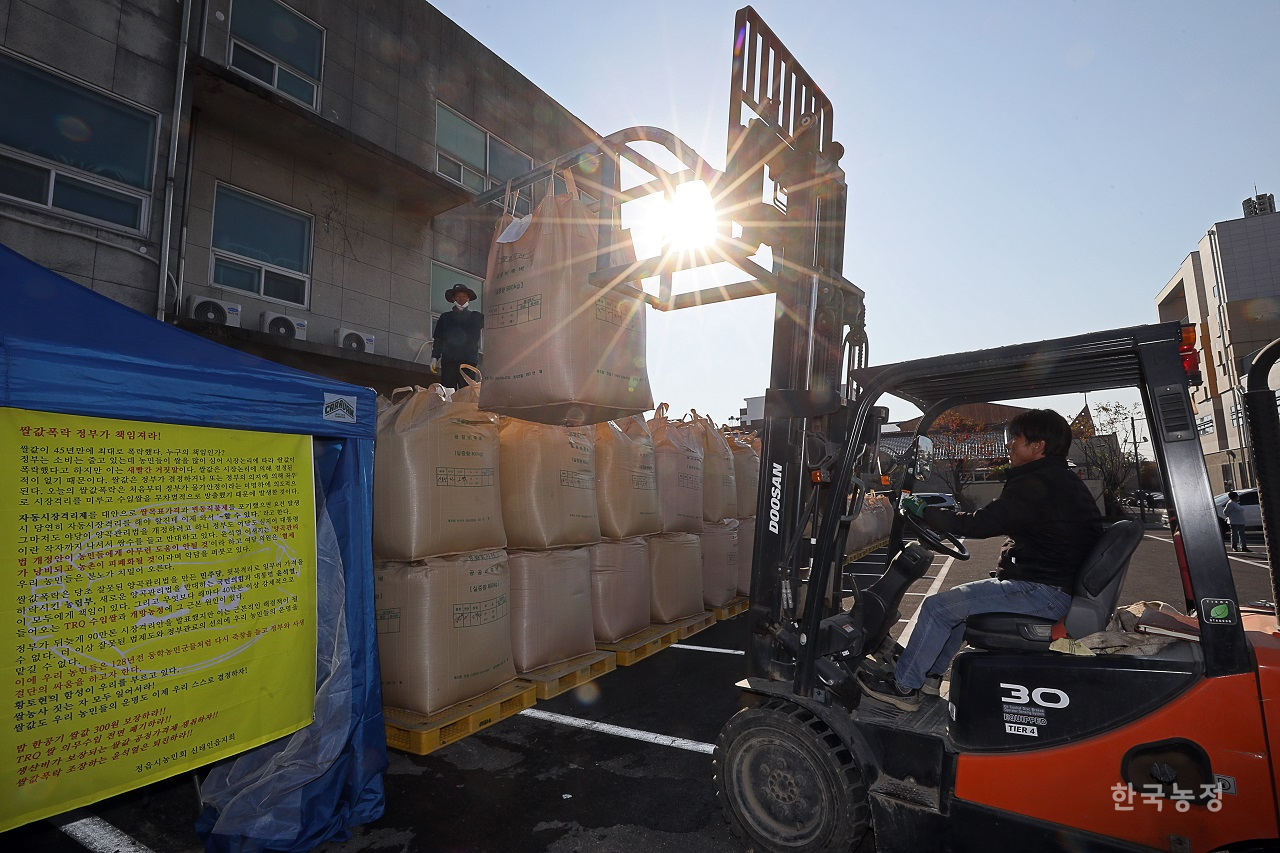 지난 25일 전북 정읍시 신태인읍사무소 앞 주차장에서 농민들이 쌀값 보장 등을 촉구하며 나락이 담긴 톤백을 쌓고 있다. 한승호 기자