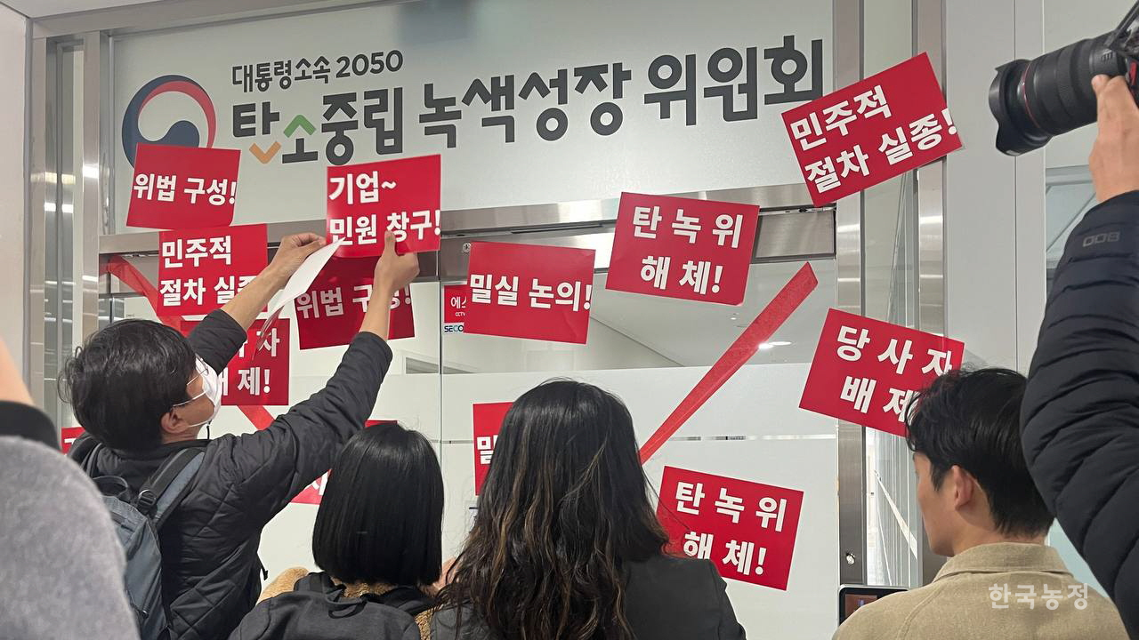 환경운동연합·녹색연합·민주노총·지역에너지전환네트워크·체제전환을위한기후정의동맹 등 기후정의운동 활동가들이 지난 15일 세종시 2050 탄소중립녹색성장위원회(탄녹위) 출입문을 봉쇄하고 연좌시위를 벌이던 중 탄녹위 입구에 '민주적 절차 실종', '밀실 논의', '당사자 배제' 등 탄녹위의 각종 문제점 및 '탄녹위 해체' 등의 구호가 적힌 피켓을 붙이고 있다. 환경운동연합 제