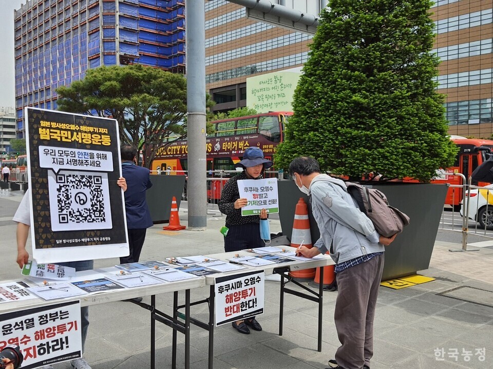 지난 2일 서울 광화문광장에서 ‘일본 방사성 오염수 해양투기 반대 범국민서명운동 선포 기자회견’이 열리는 가운데, 한 시민이 서명에 동참하고 있다.