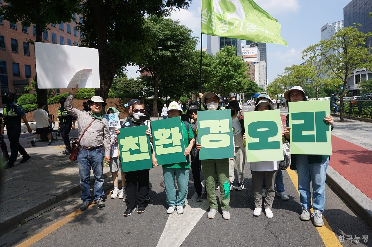 지난 20일 서울 도심에서 열린 ‘2023 몬산토·바이엘 GMO반대시민행진’에 참가한 시민들이 '친환경 오라'라고 적힌 피켓을 들고 있다. 'GMO 가고 친환경 오라'라는 이날 시민행진의 핵심 구호였다.