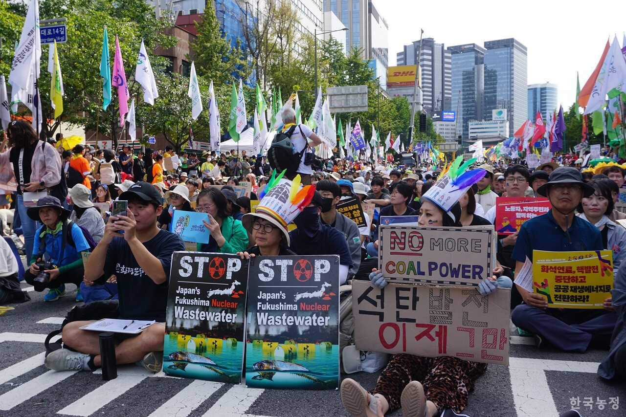 지난 23일 서울 세종대로에서 열린 9.23 기후정의행진에 참가한 시민들이 일본 정부의 핵오염수 방류 규탄 및 석탄화력발전 중단 촉구 등의 내용이 적힌 피켓을 들고 있다.