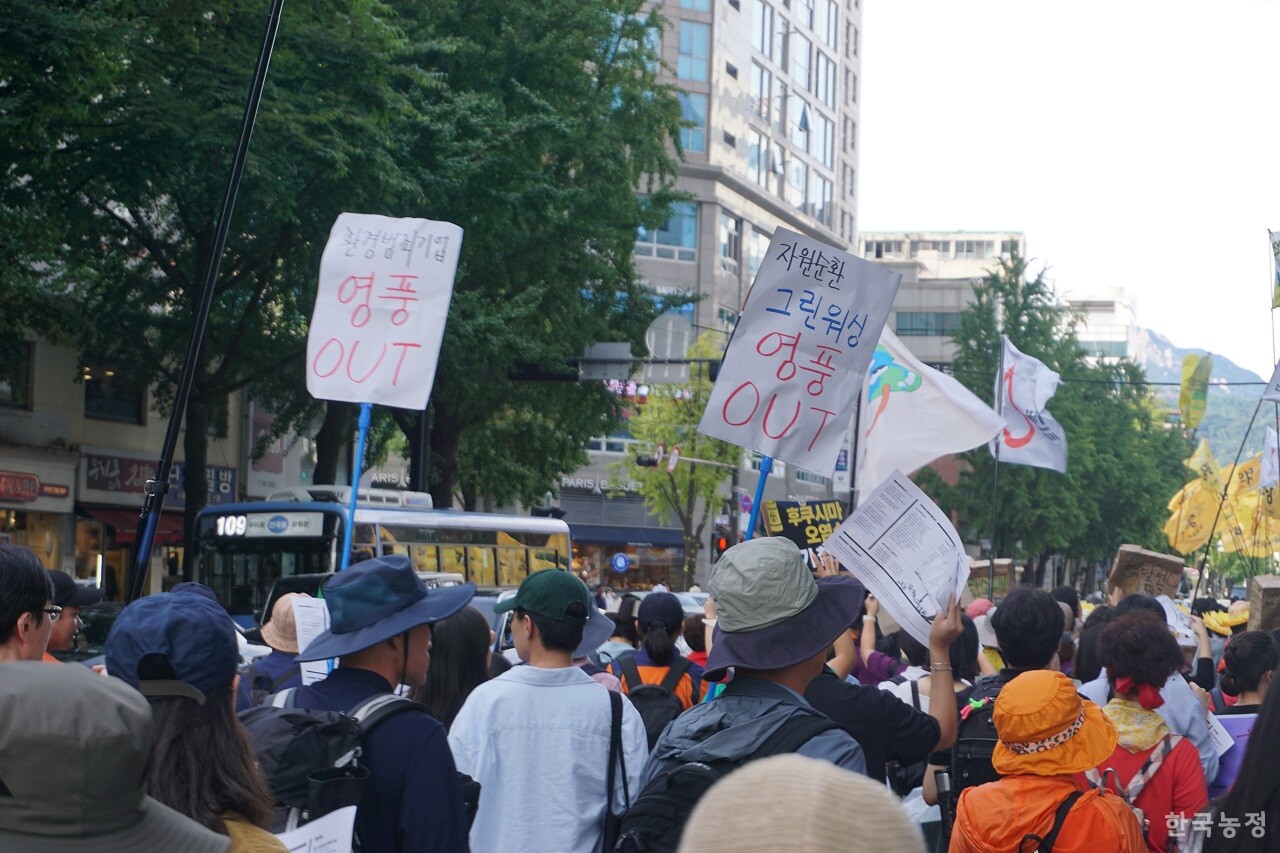지난 23일 서울 종로 거리를 행진 중인 9.23 기후정의행진 참가자 중 일부가 '자원순환 그린워싱 영풍 OUT(아웃)' 등의 구호가 적힌 손피켓을 들고 있다.