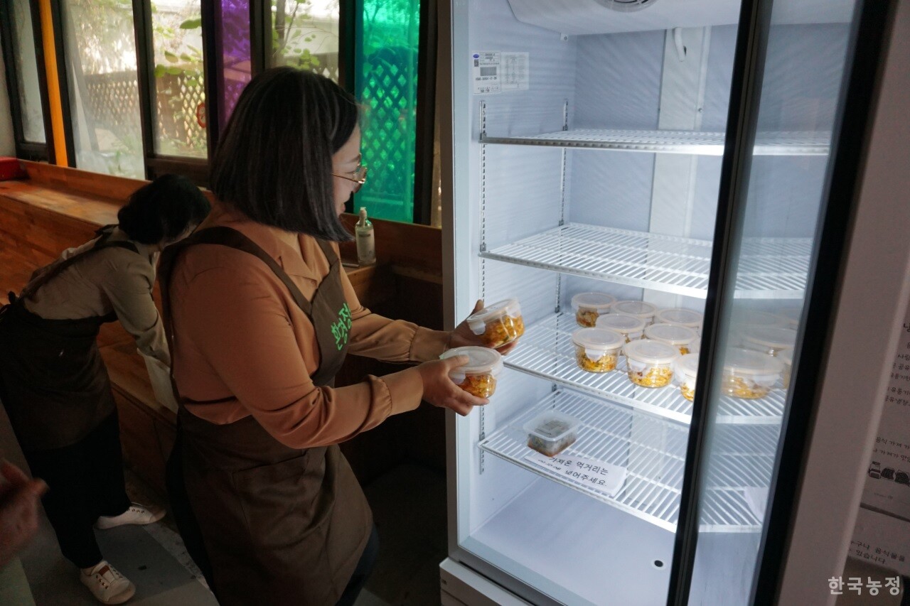 지난 4일 서울 마포구 시민공간 나루에서 진행된 환경정의 주최 ‘원데이 클래스’에 참가한 시민이 주민들과 함께 만든 마파두부를 공유냉장고에 담고 있다.