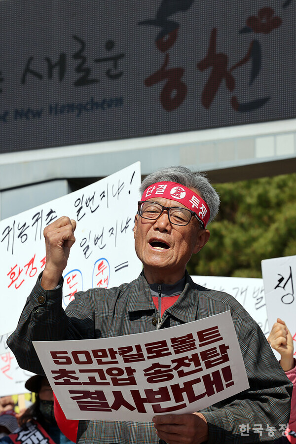 지난 2일 홍천군청 앞에서 열린 ‘농촌파괴형 난개발 저지 홍천군민대회’에서 각종 난개발 사업의 중단을 촉구하는 주민들 모습 뒤로 ‘군정구호’의 일부인 ‘새로운 홍천’이 전광판에 나타나고 있다.