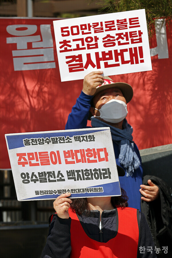 홍천군송전탑반대대책위원회와 풍천리양수발전소건설반대위원회 주민들이 요구사항이 적힌 손팻말을 들고 있다.