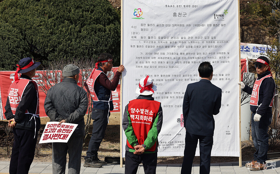 월운리골프장반대위원회 주민들이 홍천군이 주민들에게 보낸 골프장 시설을 입안하지 않겠다는 내용의 공문을 현수막에 인쇄해 집회에 참석하고 있다.