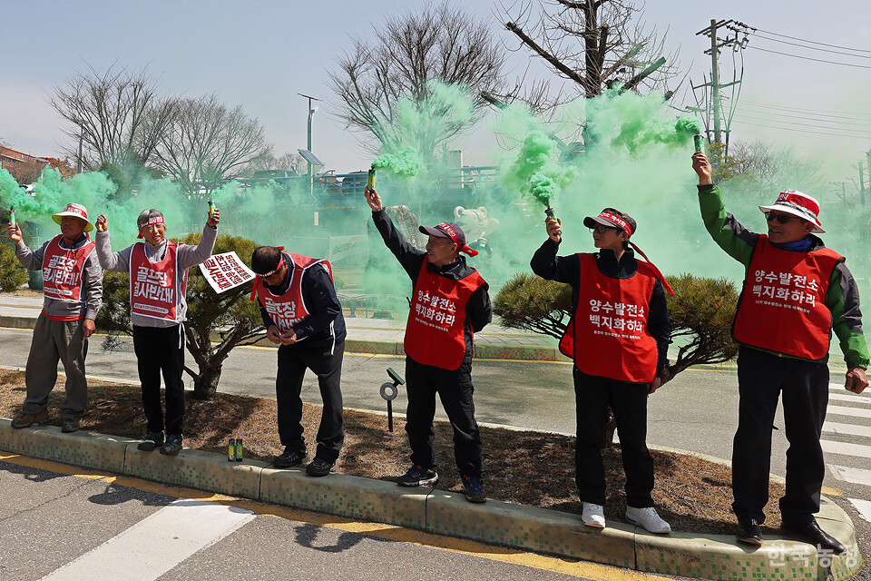주민들이 녹색연막탄을 터뜨리는 상징의식을 펼치고 있다.