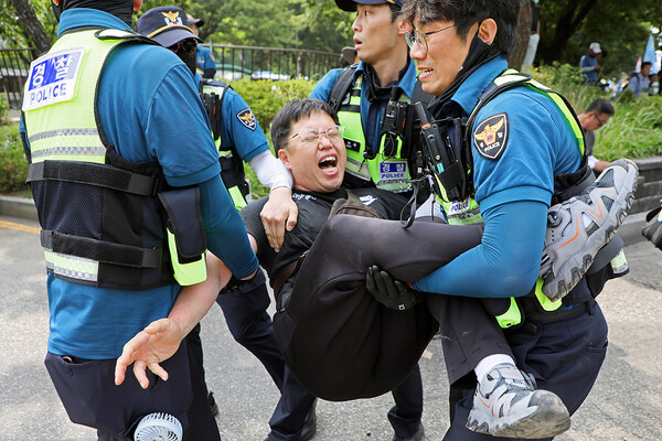 4일 오후 서울 여의도 국회의사당 앞에서 열린 ‘기후재난 시대, 농민생존권 쟁취와 국가책임농정 실현을 위한 7.4 전국농민대회’에서 한 농민이 농기계 진입을 막는 경찰에  항의하다 사지가 들린 채 연행되고 있다.  한승호 기자