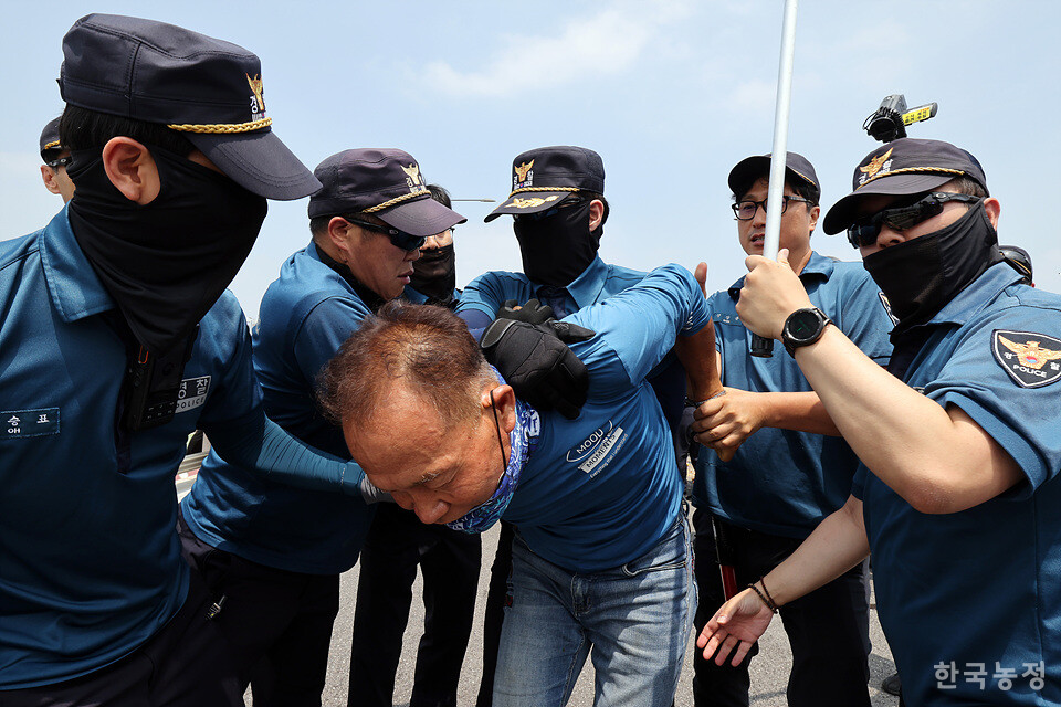 마포대교 일부 차로를 막고 행진하던 농민들 중 한 명을 경찰이 팔을 꺾은 채 연행하고 있다.