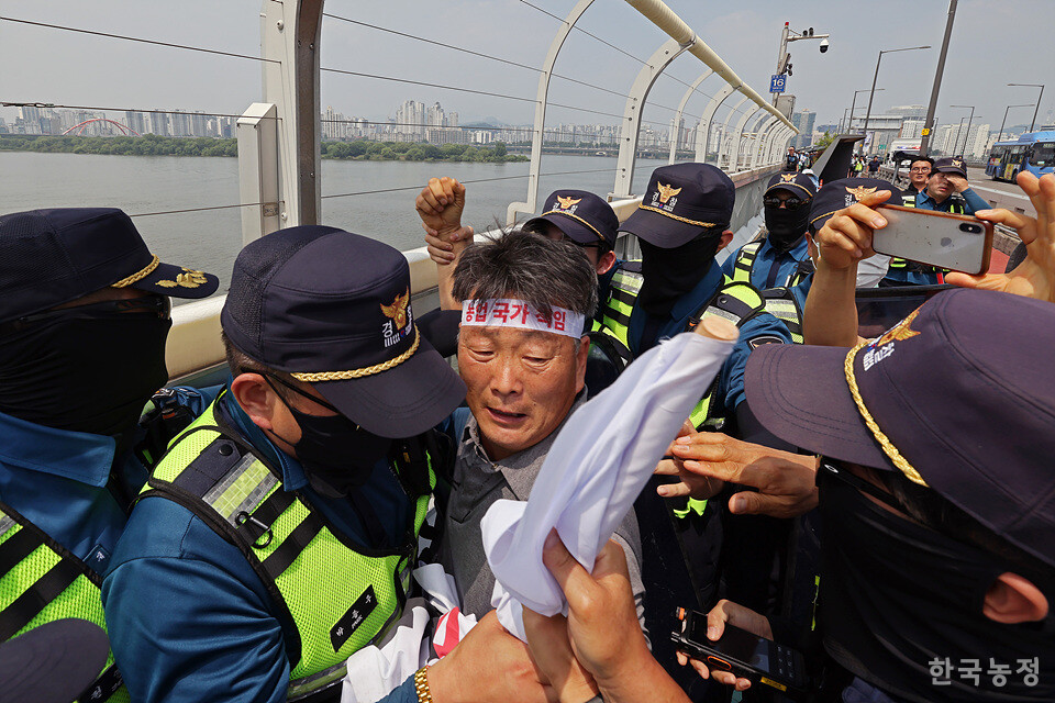 경찰들이 현수막을 빼앗기 위해 한 농민을 둘러싸고 있다.
