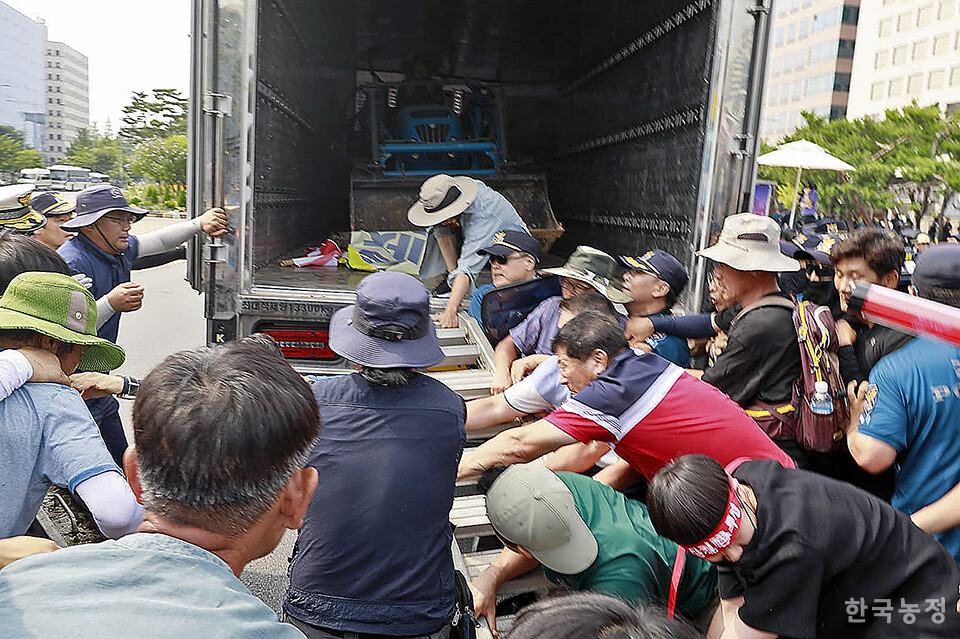 농민대회장으로 트랙터를 내리려는 농민들과 경찰들이 몸싸움을 벌이고 있다. 윤병구 기자