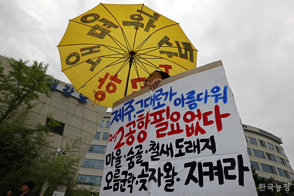 지난 10일 정부세종청사 국토교통부 앞에서 열린 '제주 제2공항 기본계획 고시중단 촉구대회'에서 한 제주도민이 제주 제2공항 건설 백지화를 촉구하는 손팻말을 들고 서 있다. 한승호 기자