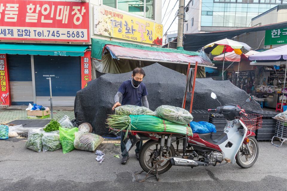 장보기가 끝나 오토바이에 짐을 싣는 어느 식당의 주인아저씨. 류관희 작가