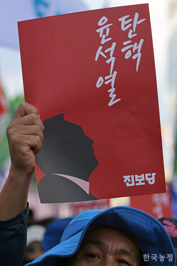 지난 28일 서울 숭례문 앞에서 열린 '퇴진광장을 열자! 9.28 윤석열정권 퇴진 시국대회'에 참석한 한 진보당원이 윤석열 탄핵을 촉구하는 손팻말을 들고 있다. 한승호 기자